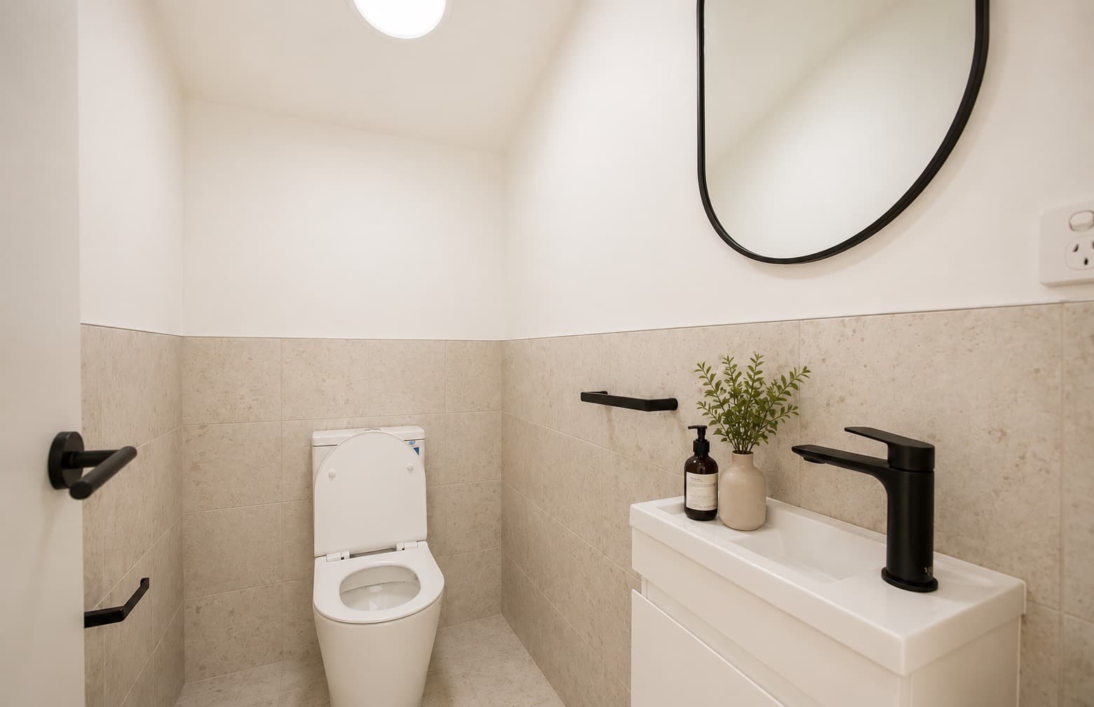 Powder room with stone-look tiling and black fixtures