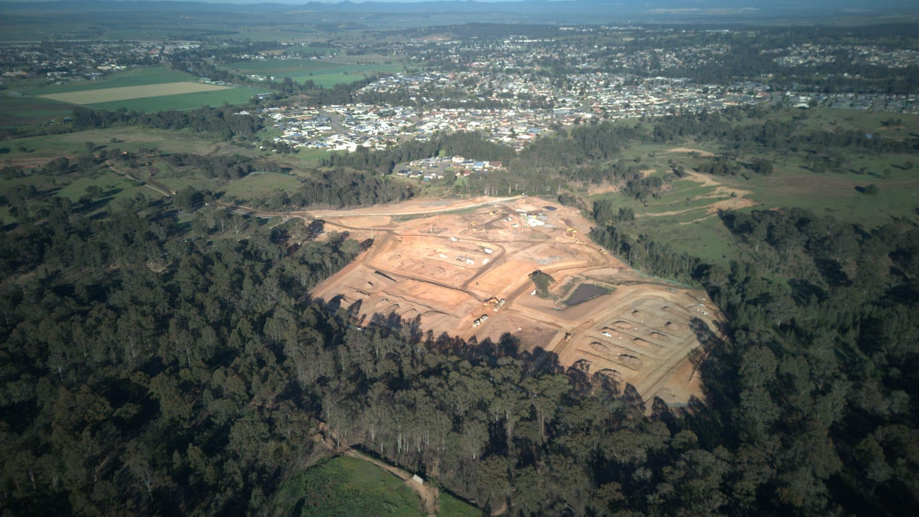 Wide aerial view of Langham Estate construction with the Singleton district beyond